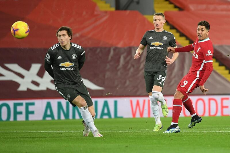 Liverpool's Brazilian midfielder Roberto Firmino (R) shoots but fails to score during the English Premier League football match between Liverpool and Manchester United at Anfield in Liverpool, north west England on January 17, 2021.  - RESTRICTED TO EDITORIAL USE. No use with unauthorized audio, video, data, fixture lists, club/league logos or 'live' services. Online in-match use limited to 120 images. An additional 40 images may be used in extra time. No video emulation. Social media in-match use limited to 120 images. An additional 40 images may be used in extra time. No use in betting publications, games or single club/league/player publications.
 / AFP / POOL / Michael Regan / RESTRICTED TO EDITORIAL USE. No use with unauthorized audio, video, data, fixture lists, club/league logos or 'live' services. Online in-match use limited to 120 images. An additional 40 images may be used in extra time. No video emulation. Social media in-match use limited to 120 images. An additional 40 images may be used in extra time. No use in betting publications, games or single club/league/player publications.
