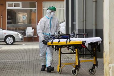 A health staff team member wearing a protective suit to protect against coronavirus enters a home in A Marina, near Lugo, northwest Spain AP