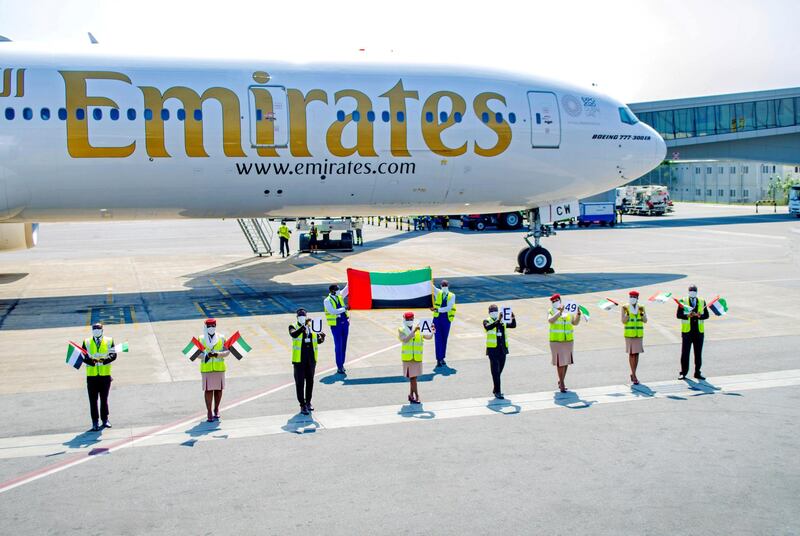Staff from the Dubai airline in Accra wave the UAE flag ahead of the UAE's 49th National Day