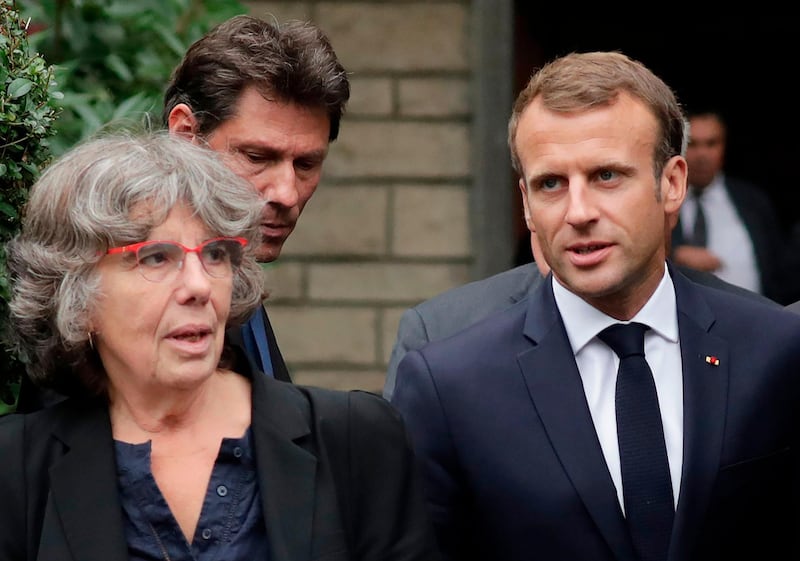 French President Emmanuel Macron (R) walks next to Michele Audin, daughter of late Maurice Audin, as he leaves the home of Josette Audin, widow of Audin, on September 13, 2018 in Bagnolet. President Emmanuel Macron acknowledged that mathematician Maurice Audin, a Communist pro-independence activist who disappeared in 1957, "died under torture stemming from the system instigated while Algeria was part of France", his office said. Macron, who was due to visit Audin's widow on September 13, will also announce "the opening of archives on the subject of disappeared civilians and soldiers, both French and Algerian". / AFP / Thomas SAMSON
