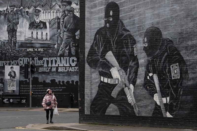 A woman walks past a Loyalist paramilitary mural on the Newtownards road in Belfast, Northern Ireland. Getty Images
