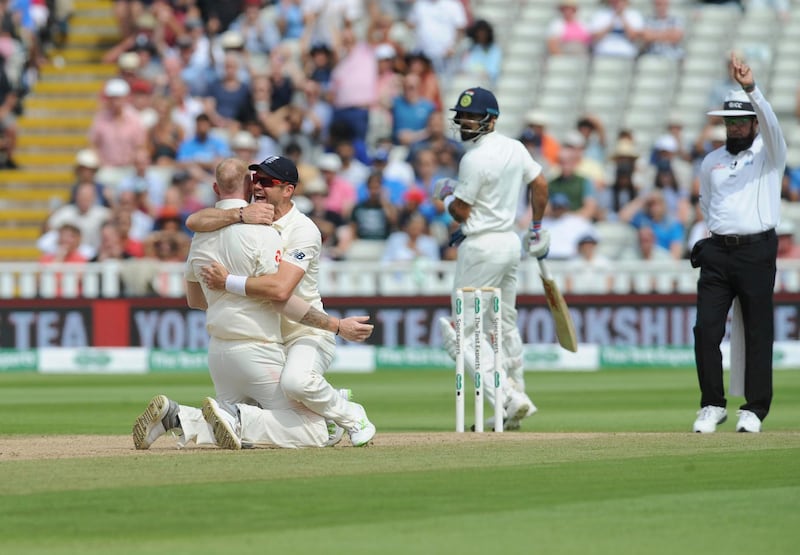 The umpire declares India captain Virat Kohli, centre, dismissed, as England's James Anderson, second left, hugs teammate Ben Stokes. AP Photo