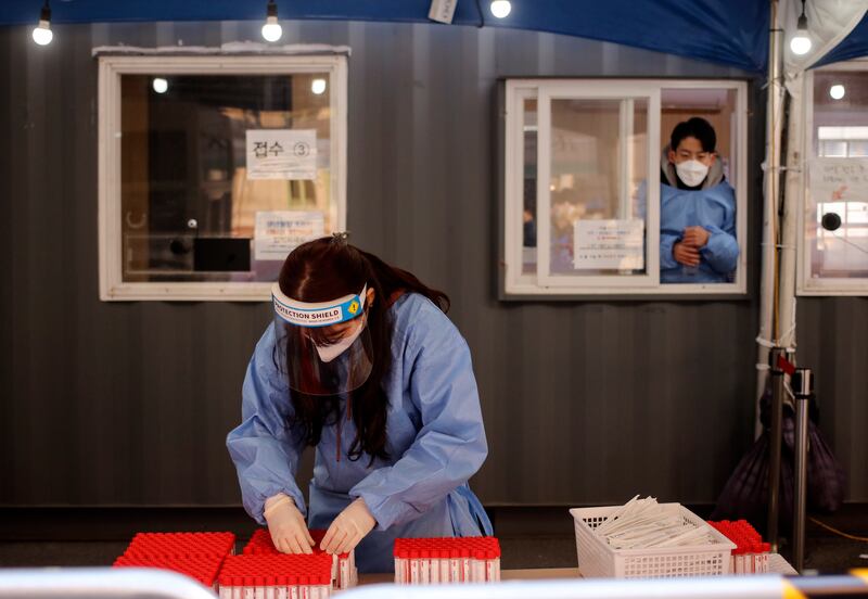 Medical workers prepare to conduct Covid-19 tests at a pop-up screening clinic in front of Seoul Station in South Korea. New coronavirus cases in the country have fallen to 7,000, but critical cases and deaths have surged to record highs of 1,083 and 109, respectively. EPA