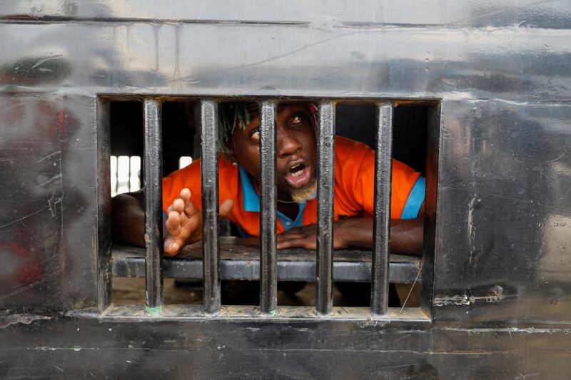 A demonstrator reacts as he is detained in a police van during a rally on the second anniversary of anti-police brutality protests that investigators said ended when security forces fired live rounds into the crowd at the Lekki toll gate, in Lagos, Nigeria October 20, 2022.  REUTERS / Temilade Adelaja     TPX IMAGES OF THE DAY