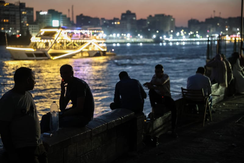 People cool off by the Nile at night during high temperatures in Cairo, as the government comes under fire from a sweltering public. Bloomberg