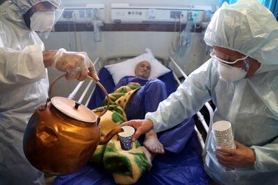 Paramedics treat a patient infected with the new coronavirus, at a hospital in Tehran, Iran, March 8, 2020. (AP Photo/Mohammad Ghadamali)