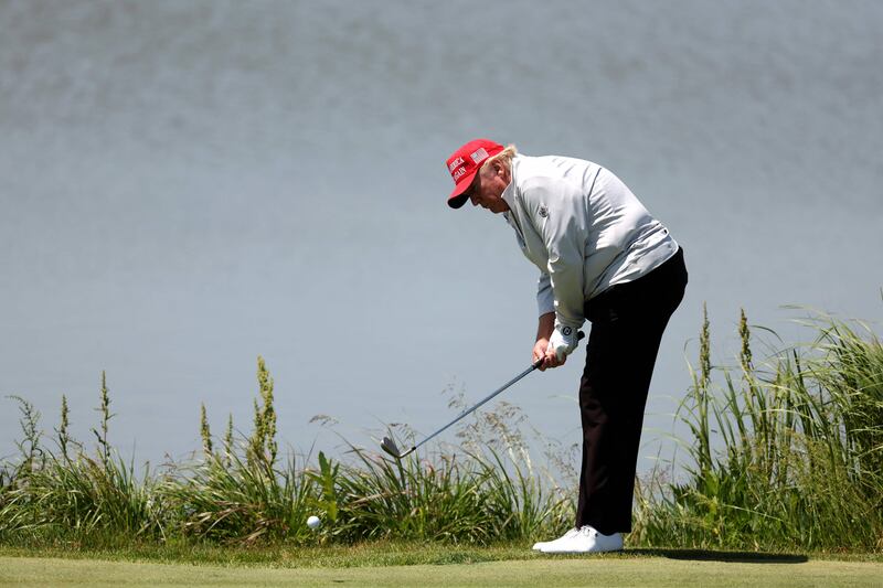 Mr Trump chips to the 11th green. AFP