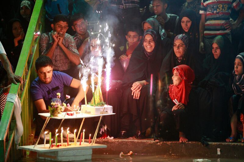 In this photo taken Thursday, July 5, 2012, Shiite pilgrims light candles and fireworks inside the courtyard of the Imam Hussein shrine during the annual festival of Shabaniyah, which marks the anniversary of the birth of the ninth-century Shiite leader known as the Hidden Imam, in Karbala, 50 miles (80 kilometers) south of Baghdad, Iraq. Religious Shiites refer to Mohammed al-Mahdi as the "Hidden Imam," believing he was spared death and will return to Earth to bring peace and justice. (AP Photo/Hadi Mizban)