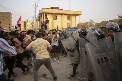 Riot police face off against protesters outside the Turkish consulate in the southern Iraqi city of Basra on Thursday. AFP