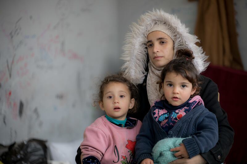 A Syrian woman and her two children in the Latakia governorate, where they live in a temporary shelter for people displaced by the February earthquake. PA