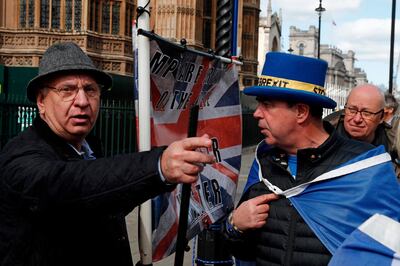 Anti-Brexit campaigner Steve Bray (2nd R) and a pro-Brexit supporter clash outside the Houses of Parliament in London on March 25, 2019. Accused of presiding over an unprecedented national humiliation in her chaotic handling of Brexit, British Prime Minister Theresa May has all but lost control of her party and her government. / AFP / Adrian DENNIS
