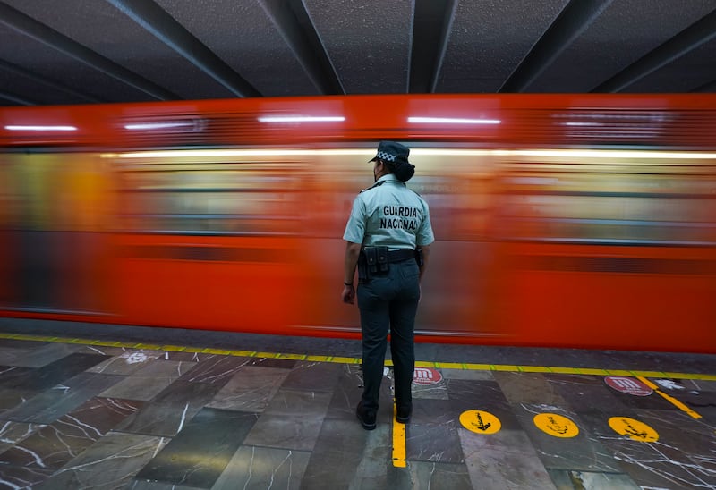 A Mexican National Guard officer watches a train pass at a subway station in Mexico City. The National Guard will be stationed in the city's subway stations after a series of accidents that officials believe are due to sabotage. AP