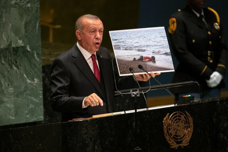 Recep Tayyip Erdogan, Turkey's president, holds up a photograph of deceased Syrian refugee Alan Kurdi while speaking during the UN General Assembly meeting in New York, U.S., on Tuesday, Sept. 24, 2019. Erdogan used his speech to reinforce his image as a champion of the underdog -- and particularly of Muslims he says are being oppressed. Photographer: Jeenah Moon/Bloomberg