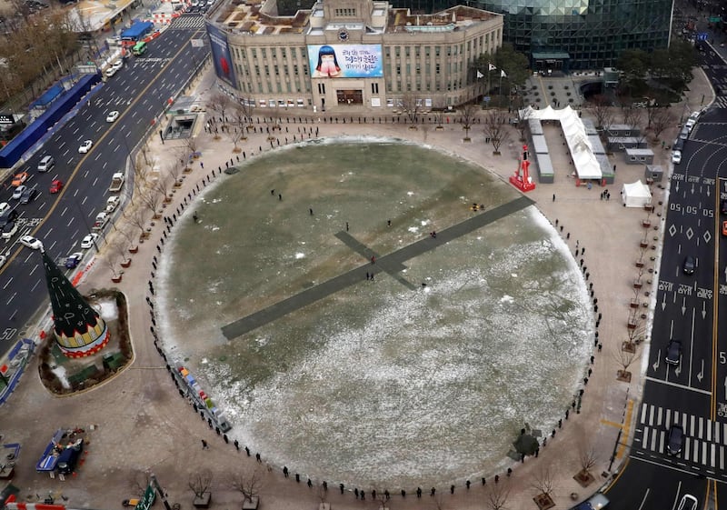 A general view shows people queueing to receive tests for the Covid-19 novel coronavirus at a temporary facility at City Hall Plaza in Seoul on December 18, 2020.  - South Korea OUT / NO ARCHIVES -  RESTRICTED TO SUBSCRIPTION USE
 / AFP / YONHAP / - / NO ARCHIVES -  RESTRICTED TO SUBSCRIPTION USE
