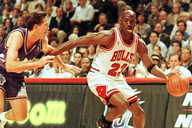 (FILES) In this file photo taken on June 4, 1997 Chicago Bulls player Michael Jordan sticks out his tongue as he goes past Jeff Hornacek of the Utah Jazz during game two of the NBA Finals at the United Center in Chicago, IL. The immense global success of the documentary "The Last Dance" amid the coronavirus lockdown has boosted sales of collectibles related to NBA icon Michael Jordan, some of which are trading in the hundreds of thousands of dollars. - / AFP / VINCENT LAFORET