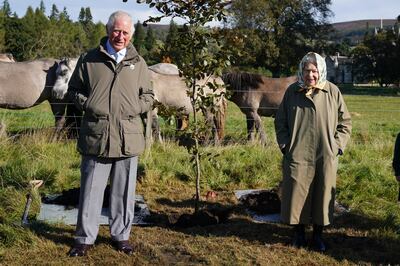 Queen Elizabeth and Prince Charles pose after planting a tree at the Balmoral Cricket Pavilion, to mark the start of the official planting season for the queen's Green Canopy. Getty Images
