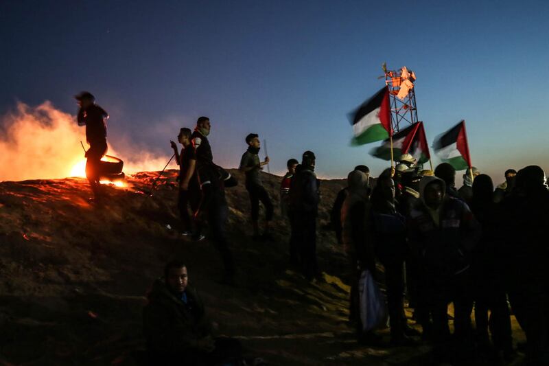 TOPSHOT - Palestinian protesters take part in a night demonstration near the fence along the border with Israel, in Rafah in the southern Gaza Strip, on March 19, 2019. The often violent protests are demanding Palestinian refugees and their descendants be allowed to return to former homes now inside Israel. Israeli officials say that amounts to calling for the Jewish state's destruction, and accuse Hamas, the Islamist movement that runs the Gaza Strip, of orchestrating the protests.
 / AFP / SAID KHATIB

