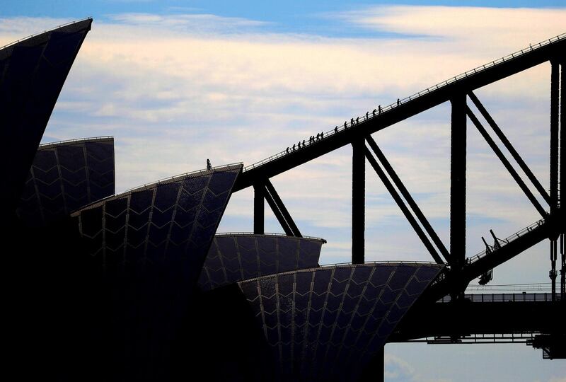 The roof of the Sydney Opera house can be seen in front of tourists as they climb the Sydney Harbour Bridge in Australia. Reuters