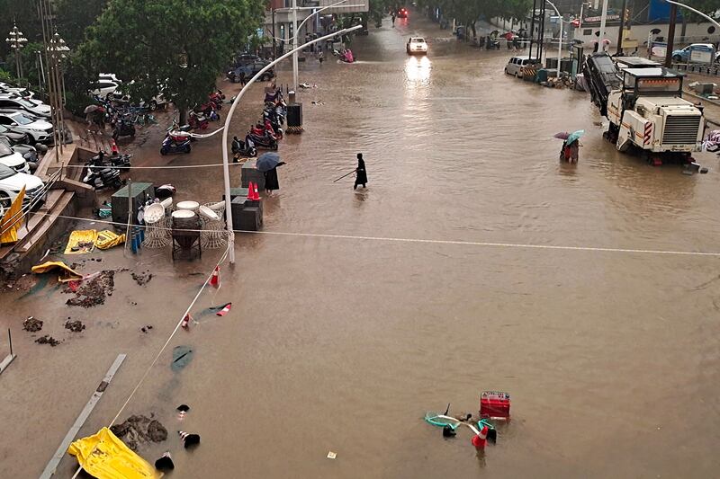 People wade through floodwater in Zhengzhou.