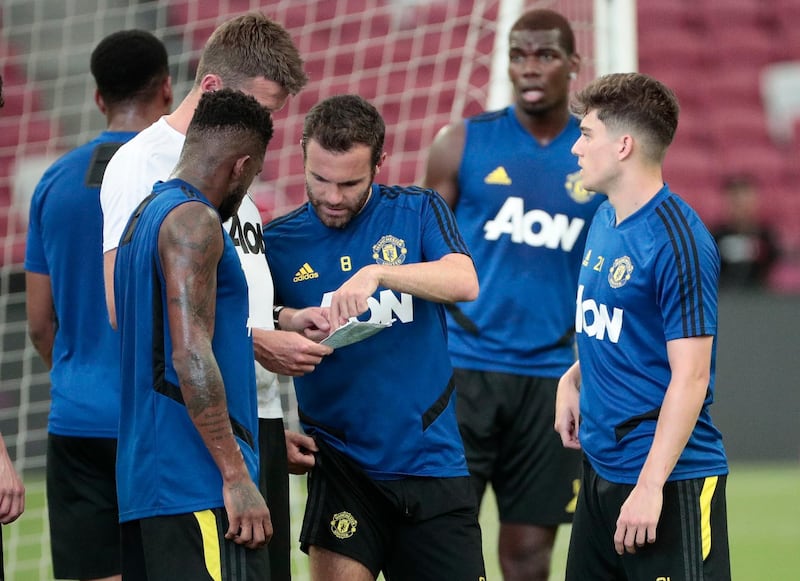 epa07726511 Manchester United players Juan Mata (C) and Daniel James (R) speak to a coach during a training session ahead of the International Champions Cup match between Manchester United and Internazionale at the National Stadium in Singapore, 19 July 2019.  EPA/WALLACE WOON