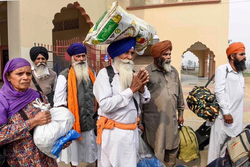 Sikh pilgrims return from Pakistan where they celebrated the 550th birth anniversary of Sikhism founder Guru Nanak Dev at the India-Pakistan Wagah Post about 35 kms from Amritsar on November 13, 2019. / AFP / NARINDER NANU
