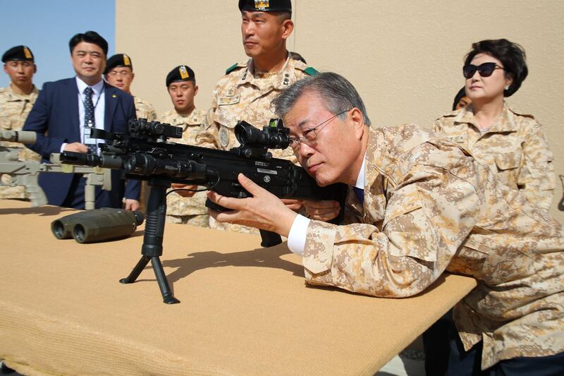 South Korean President Moon Jae-in takes up a shooting position as he visits a contingent of the Akh unit, a South Korean military detachment stationed in Abu Dhabi. Moon is on a four-day visit to the UAE.  EPA / Yonhap