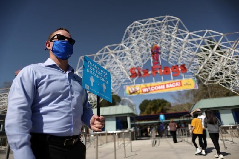 People enter Six Flags Magic Mountain amusement park on the first day of opening, as the coronavirus disease (COVID-19) continues, in Valencia, California, U.S. REUTERS
