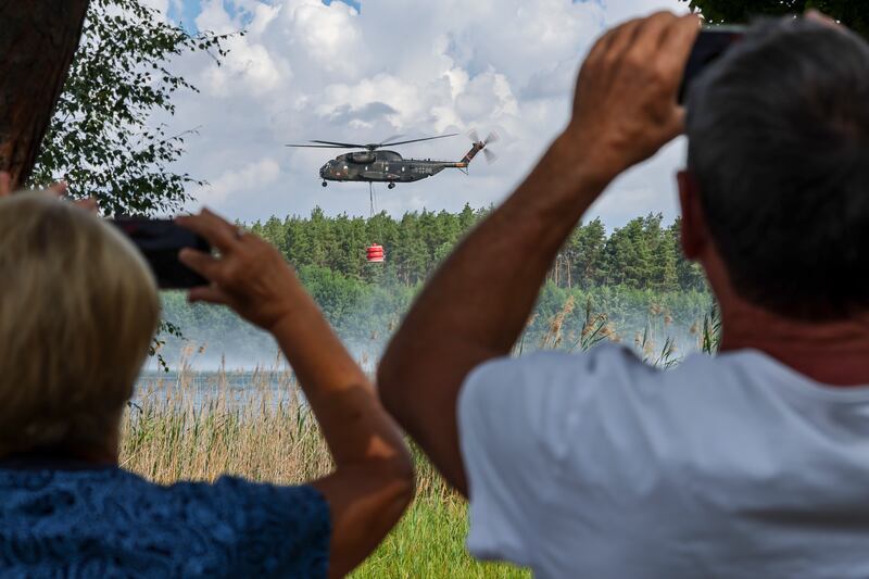 A helicopter loads water from the sea in Falkenberg, Germany, to dump on wildfires. AP