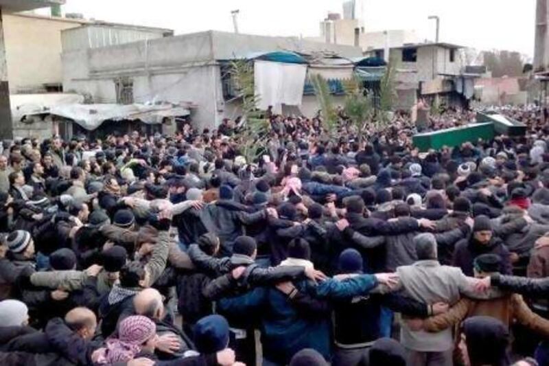 A crowd follows mourners carrying coffins of protesters allegedly killed during anti-governement protests in Damascus yesterday. The funeral was being held for three people, including two teenagers, who died on Thursday.