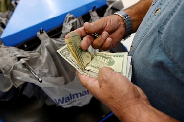 FILE PHOTO: A customer counts his cash at the checkout lane of a Walmart store in the Porter Ranch section of Los Angeles, California, U.S., November 26, 2013. To match Insight USA-ECONOMY/CONSUMERS. REUTERS/Kevork Djansezian/File Photo