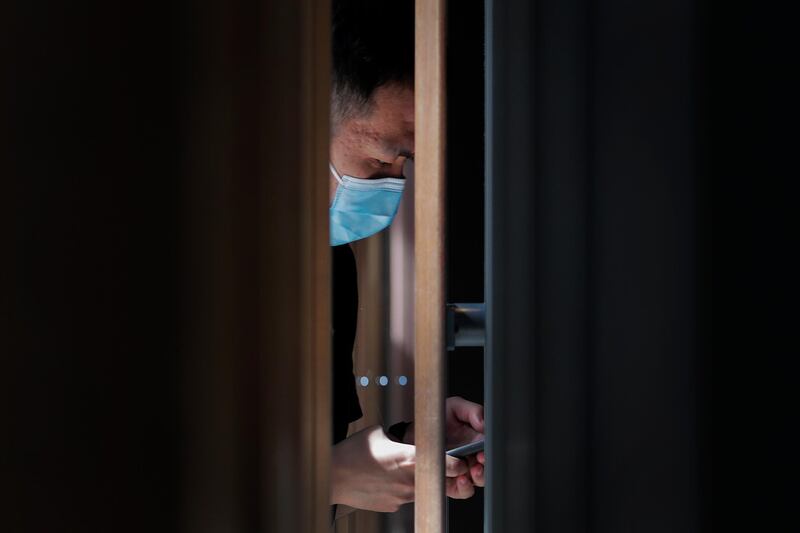 A man opens his health code on his smartphone before entering a cafe at a shopping district in Beijing, China. AP Photo