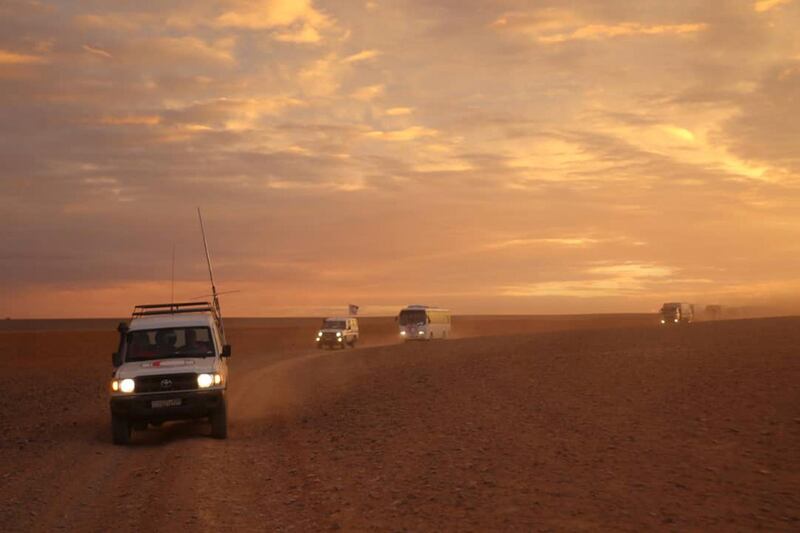 This photo released by the Syrian Arab Red Crescent, shows a convoy of vehicles of the Syrian Arab Red Crescent driving in the Syrian desert heading to Rukban camp between the Jordan and Syria borders, Sunday, Nov. 4, 2018. U.N. officials and volunteers from the Syrian Arab Red Crescent offered vaccinations for children Sunday and distributed much needed aid, the first such assistance since January to reach thousands of people in a remote camp for the displaced on Syria's border with Jordan. Residents say it is the first time they see international humanitarians roaming their desolate camp, where nearly 50,000 have been stranded in a political void. (Syrian Arab Red Crescent via AP)