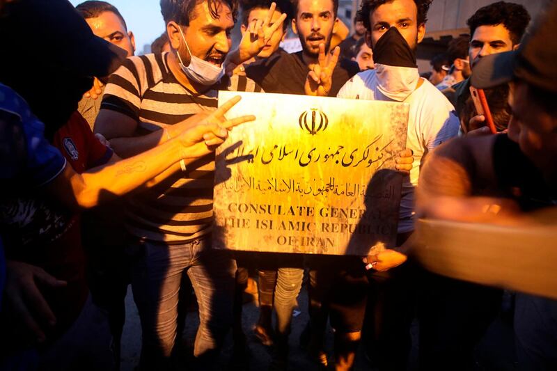 Protesters hold a sign belonging to the Iranian consulate building before storming and burning it in Basra, 340 miles (550 km) southeast of Baghdad, Iraq, Friday, Sept. 7, 2018. Hundreds of angry protesters in Basra took to the streets on Thursday night. Some clashed with security forces, lobbing Molotov cocktails and setting fire to a government building as well as the offices of Shiite militias. At least three people were shot dead in confrontations with security forces. (AP Photo/Nabil al-Jurani)
