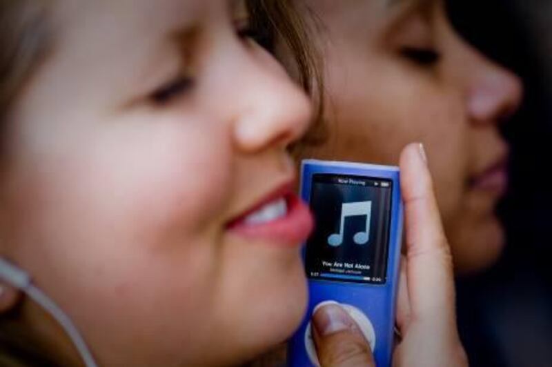 LOS ANGELES - JUNE 25: Lesley Gant (L) and Yvonne Ordiz (R) listen to Michael Jackson's music on an ipod outside the UCLA medical Center on June 25, 2009 in Los Angeles, California. Jackson, 50, the iconic pop star, died after going into cardiac arrest in a hospital today in Los Angeles, California.   Michal Czerwonka/Getty Images/AFP