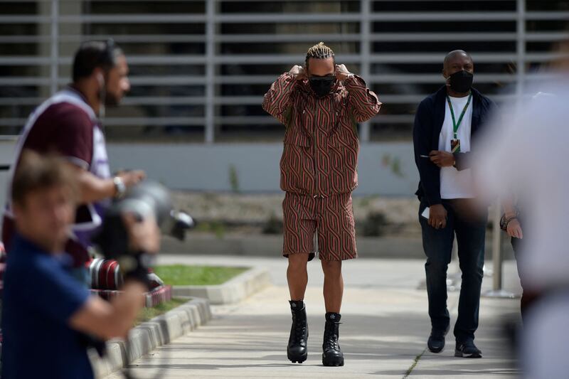 Lewis Hamilton, in a black and red Ahluwalia parka and short set, arrives ahead of the Bahrain Grand Prix at Bahrain International Circuit on March 20, 2022. AFP