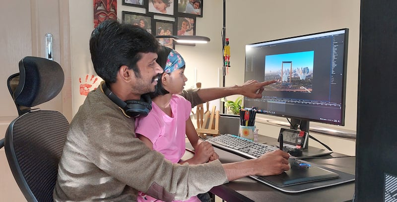 Jagadisha shows his daughter, Vipanchi, the video he created for her.