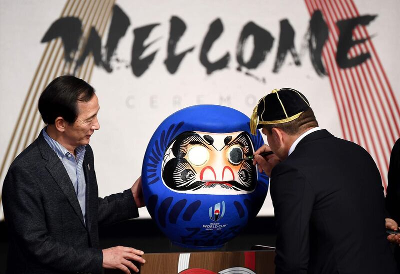 France's hooker Guilhem Guirado paints on a Japanese daruma doll at the Kawaguchiko theatre. AFP