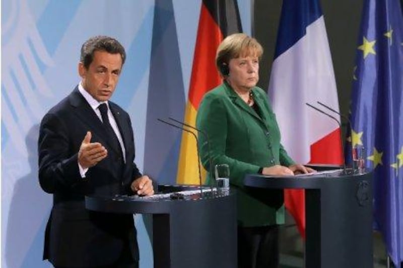 French President Nicolas Sarkozy and German Chancellor Angela Merkel arrive to speak to the media after talks at the Chancellery in Berlin yesterday. Sean Gallup / Getty Images)
