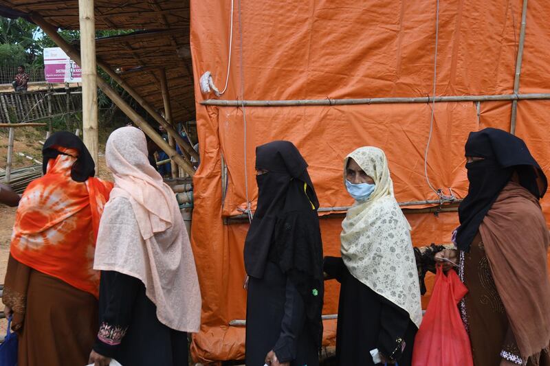 Rohingya refugees wait in a queue to collect relief supplies at Kutupalong refugee camp. AFP