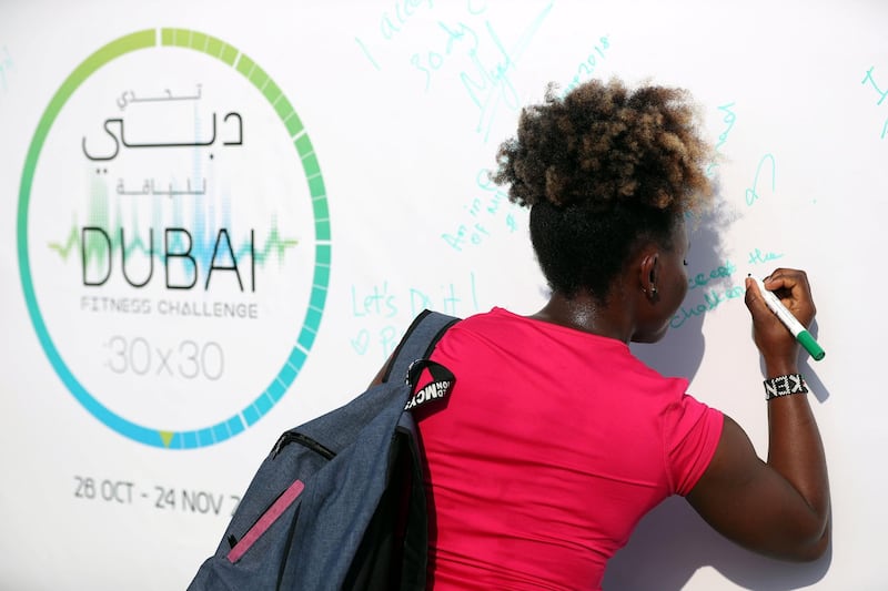 Dubai, United Arab Emirates - October 26, 2018:  A lady signs the board saying "Except the Challenge" at Dubai Fitness Challenge. The Crown Prince of Dubai renews his emirate-wide call for every resident to take part in 30 minutes of exercise for 30 days. Friday, October 26th, 2018 Festival City Mall, Dubai. Chris Whiteoak / The National