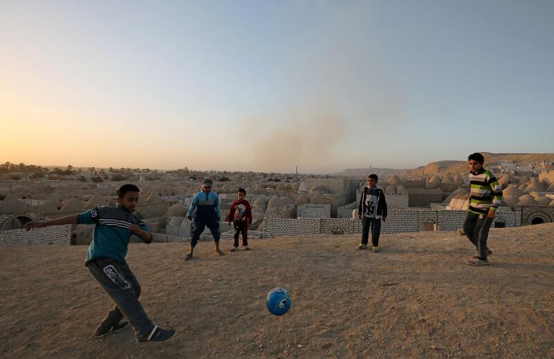 Children play football at the graveyards. Reuters