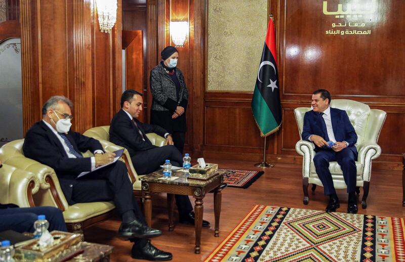 Italian Foreign Minister Luigi Di Maio (C) meets with new Libyan Prime Minister Abdul Hamid Dbeibah (R) in the capital Tripoli on March 21, 2021.  / AFP / -
