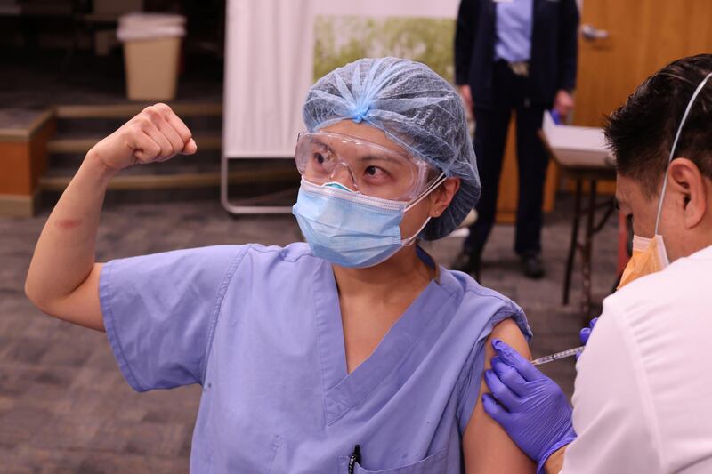 Physician Joyce Limurti, 40, flexes her bicep as she is given the coronavirus disease (COVID-19) vaccine at Dignity Health Glendale Memorial Hospital and Health Center in Glendale, California, U.S. REUTERS