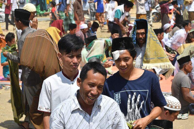 Indonesian Muslims disperse following congregational Friday prayers on a field near temporary shelters in Pemenang, northern Lombok.  AFP