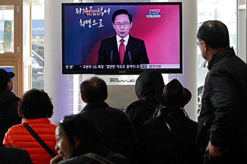 Commuters at a Seoul train station watch the South Korean president, Lee Myung-bak, deliver a new year's speech on television where he said the peninsula is at a crucial turning point.