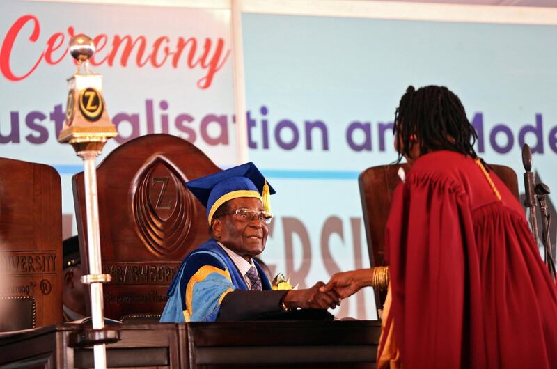 epa06336056 Zimbabwean President Robert Mugabe (C) makes his first public appearance four days after the Zimbabwe National Army took over control of government, at an Zimbabwe Open University (ZOU) graduation ceremony in Harare, Zimbabwe, 17 November 2017. The president of Zimbabwe presided over a graduation ceremony at a university in Harare, his first public appearance since the military took to the streets against his government and he was detained in his home.  EPA/AARON UFUMELI
