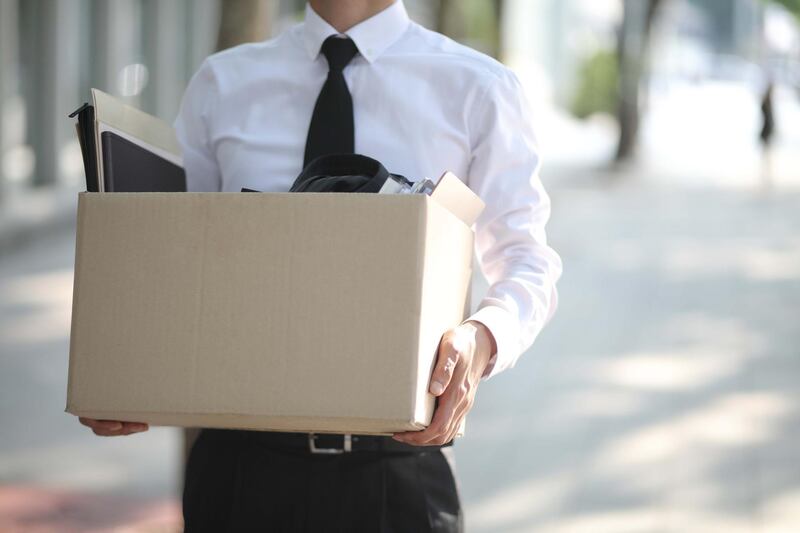 Close-up Of Unemployed Businessperson Carrying Cardboard Box. Getty Images