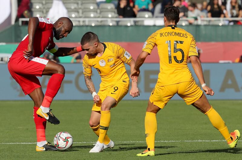 Palestine's Abdellatif Bahdari, left, fights for the ball with Australia's Jamie Maclaren, centre, and Chris Iknonomidis. AFP