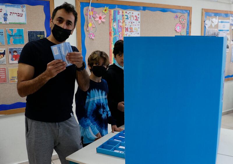 A man votes with his children in Tel Aviv on the fourth national election in two years.  AFP