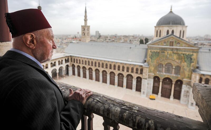 Mohammad Ali Al Sheikh, the eldest of the Muezzins who call Muslims to prayer at the Umayyad Mosque in ancient Damascus, stands on a balcony. AFP